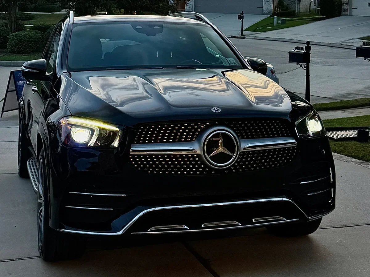 Detailed Mercedes SUV with reflections across its hood at sunset